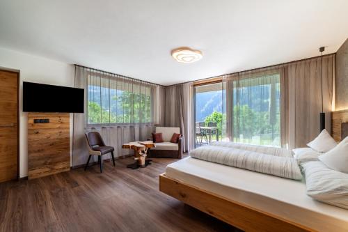 a hotel room with a bed and a tv and windows at Chalet Riad 2 in Saltusio