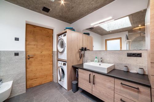 a bathroom with a sink and a washing machine at Chalet Riad 2 in Saltusio