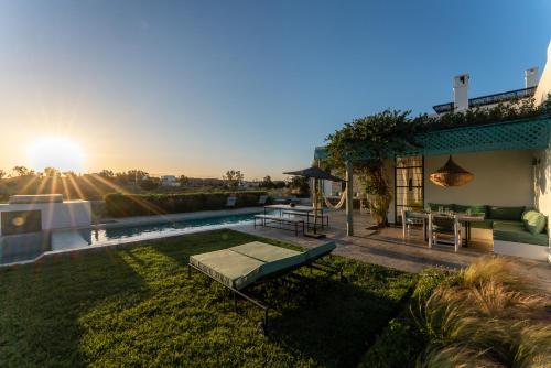 a backyard with a pool with a table and a bench at Villa Celeste-Essaouira, piscine chauffée, vue sur la campagne in Essaouira