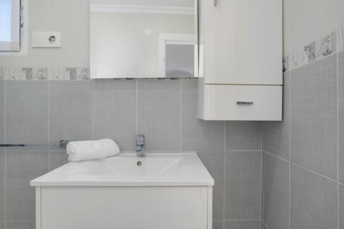 a bathroom with a white sink and white cabinets at Piso Acogedor Tarifa Centro in Tarifa