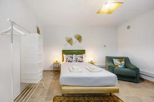 a bedroom with a bed and a green chair at Villa Tucha in Alvor
