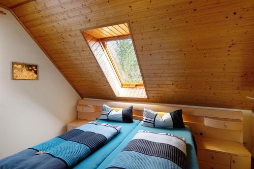 two beds in a attic room with a window at Süd-Balkon an der schönen Peene in Demmin