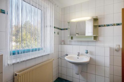 a white bathroom with a sink and a window at Süd-Balkon an der schönen Peene in Demmin