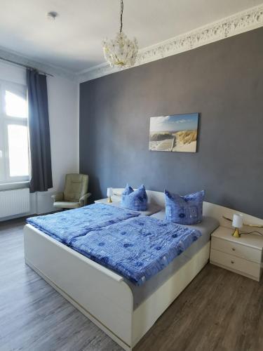 a bedroom with a large bed with blue sheets and blue pillows at Villa Adler- Seeseite in Ahlbeck