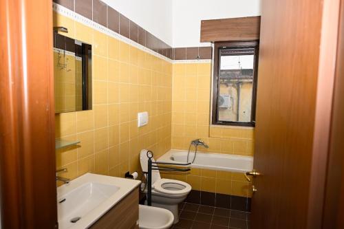 a bathroom with a toilet and a sink and a tub at La casetta di Claudia in Nettuno