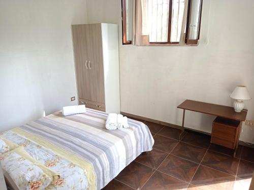 a bedroom with a bed and a table and a window at Germogli di Prumo in Castelnuovo Cilento