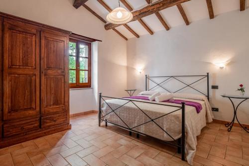 a bedroom with a bed and a wooden cabinet at Girasole in Arcidosso