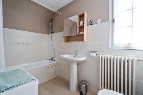 a bathroom with a sink and a toilet and a bath tub at Maison De Caractère in Cancale
