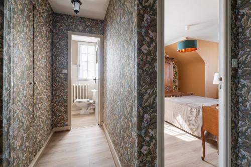 a corridor of a room with a bed and a bathroom at Maison De Caractère in Cancale