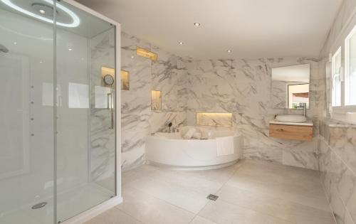 a bathroom with a tub and a glass shower at Can Luciana in La Aranjasa