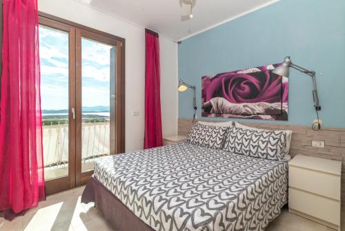 a bedroom with a bed and a large window at B 104 Puntavilla Mare in La Maddalena