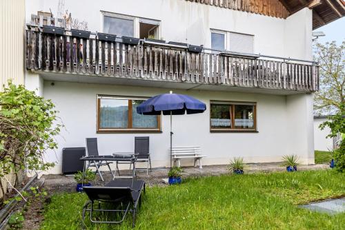 a patio with an umbrella and a table and chairs at Ferienwohnung-4you in Sigmarszell