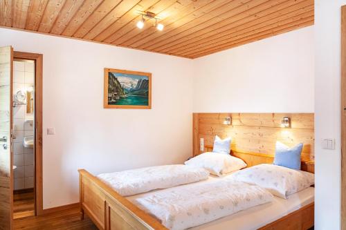 two beds in a room with white walls and wooden ceilings at Ferienwohnung - Hexi in Bad Kohlgrub