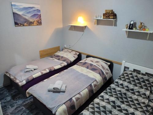 two beds in a small room with towels on them at Wohnung in Elz in Elz