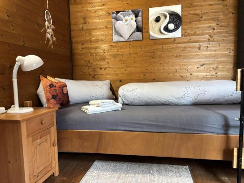 a bed in a room with a wooden wall at Ferienwohnung Herzogenhorn in Bernau im Schwarzwald