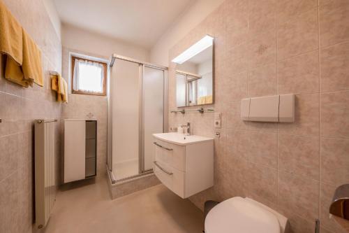 a bathroom with a toilet and a sink and a mirror at Stompferhof Erkerwohnung in Caldaro