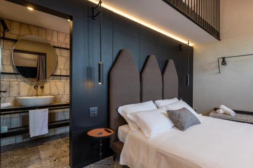 a bedroom with a bed and a bathroom with a sink at Suite Limonaia in San Gimignano