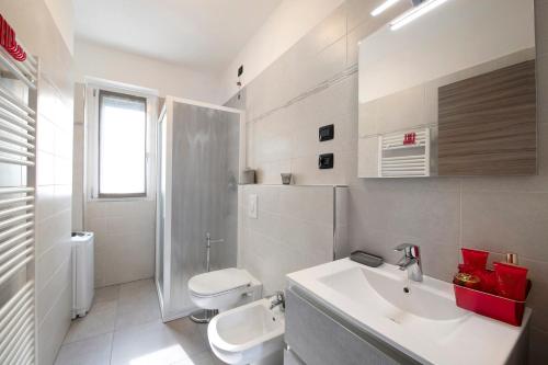 a white bathroom with a sink and a toilet at Appartamento 6 Il Tornante in Nesso