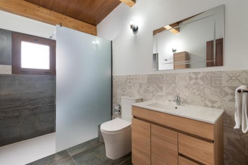 a bathroom with a sink and a toilet and a mirror at Vv El Mirador in El Palmital