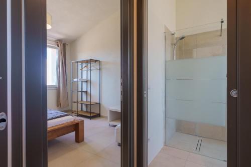 a bathroom with a shower and a glass door at Il Sughereto In Vigna in Aglientu