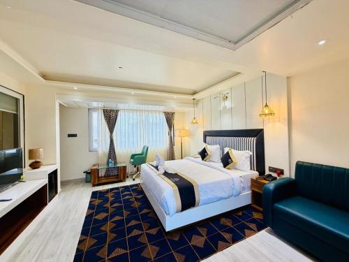 a hotel room with a bed and a couch at Hotel Kama, Patna in Patna