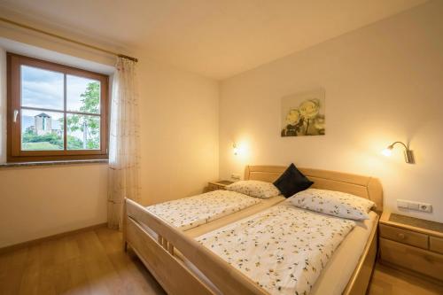 a bedroom with a bed and a window at Stettnerhof Wohnung Laugen in Vollan