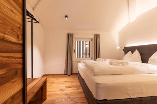 a bedroom with a large bed and a window at Innerbachlerhof - Laugen in Postal
