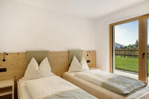 a bedroom with two beds and a large window at Masi Rosmarin in Santa Valpurga