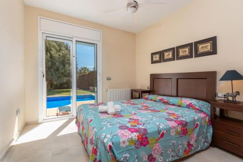 a bedroom with a bed and a large window at Villa Elodia in Calonge
