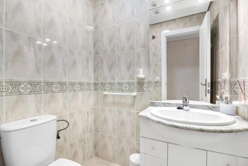 a white bathroom with a toilet and a sink at Ca Blanca Paraíso ll in Denia