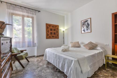a white bedroom with a bed and a window at Casa Magnolia P1 in Seccheto