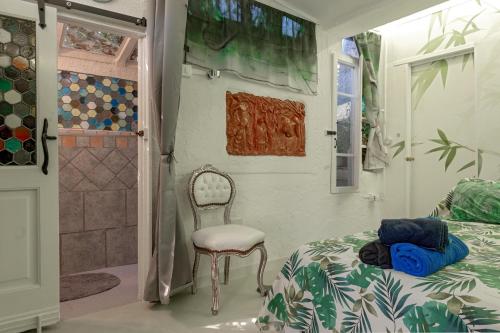 a bedroom with a bed and a chair and a shower at Stanza Verde degli Artisti in Rosignano Marittimo