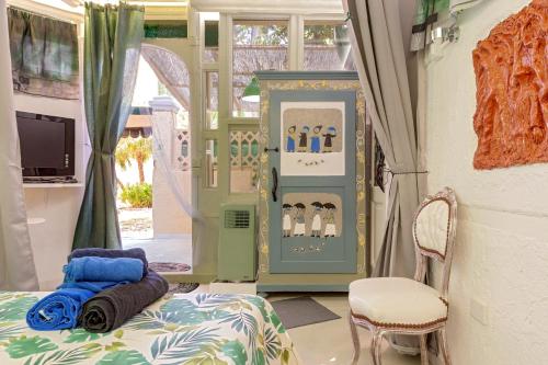 a room with a bed and a chair and a window at Stanza Verde degli Artisti in Rosignano Marittimo