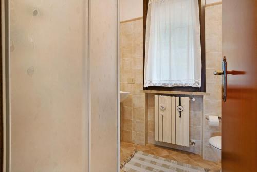 a bathroom with a shower and a toilet and a window at Stella del Garda 1 con balcone in Tignale
