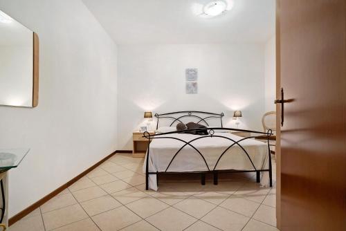 a bedroom with a bed and a tiled floor at Stella del Garda 1 con balcone in Tignale