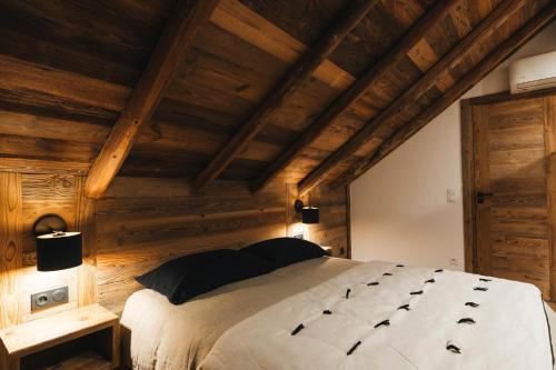a bedroom with a large bed with wooden walls at Gîte Maria in La Tour