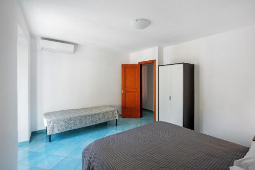 a bedroom with two beds and a bench and a refrigerator at Ce Tour - Casa Cetara Centro in Cetara