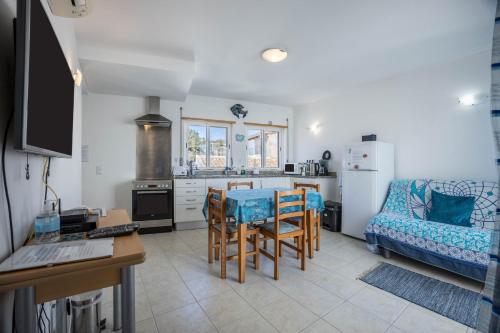 a kitchen and living room with a table and a couch at Casa Da Paz in Salema