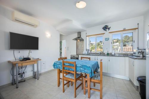 a kitchen with a table and a tv in a room at Casa Da Paz in Salema