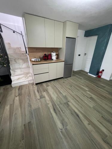 a kitchen with white cabinets and a wooden floor at Cabana Patric Valea Avrigului in Avrig