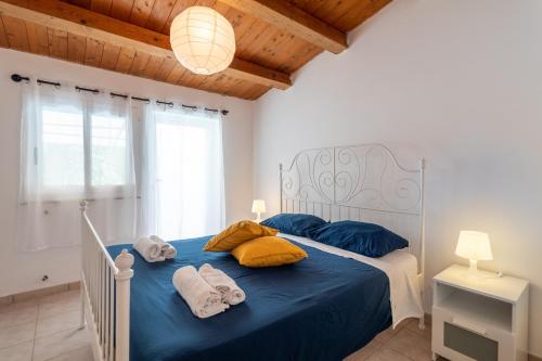 a bedroom with a bed with blue sheets and yellow pillows at Villa Arianna in Ragusa
