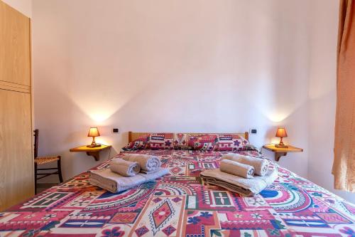 a large bedroom with a large bed with a colorful rug at House Leoni in Isola Rossa