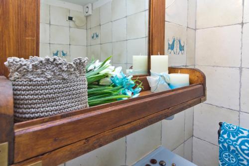 a shelf in a bathroom with candles and flowers at Casa Ginepro in Quartu SantʼElena