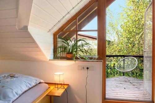 a bedroom with a window and a bed and a balcony at Ferienhaus Reis in Ostrach