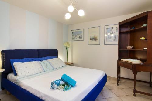 a bedroom with a bed with a blue head board at Casa Ginepro in Quartu SantʼElena