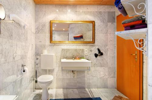 a bathroom with a sink and a toilet and a mirror at Ferienhaus Reis in Ostrach