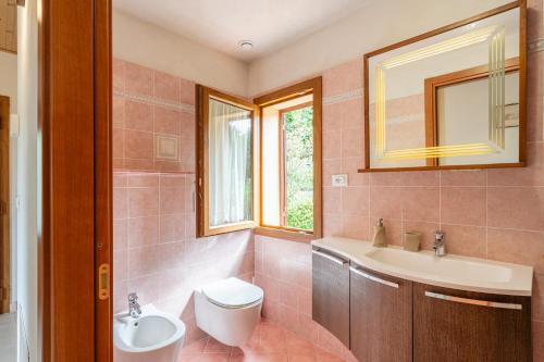 a bathroom with a sink and a toilet and a mirror at Villetta Allegra in Prataccio