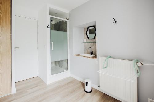 a bathroom with white walls and a sink and a mirror at Maison Conviviale 3 Vallées in Novallay