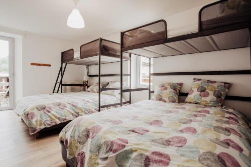 two beds in a room with two bunk beds at Maison Conviviale 3 Vallées in Novallay