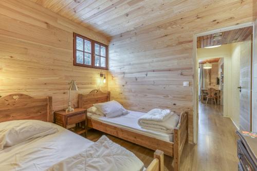 a bedroom with two beds in a wooden cabin at Gawal 1 in Villard-Reculas